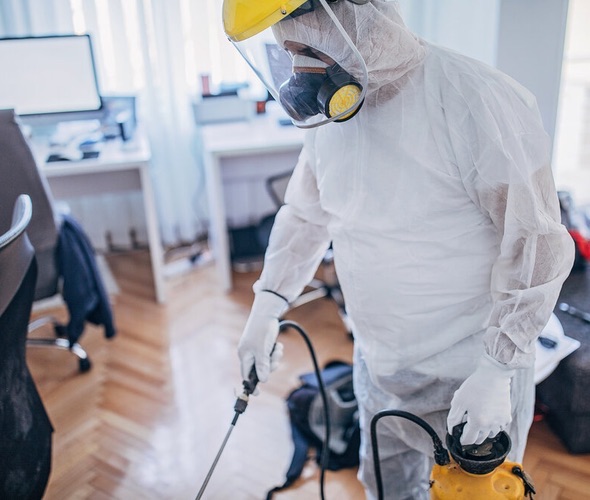 Sanificazione ambienti Genova ServiceClean - Operatore specializzato che igienizza un ufficio moderno con attrezzatura professionale.